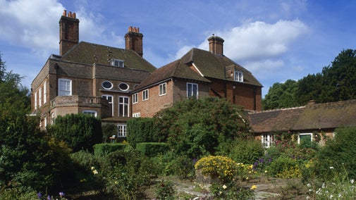 View across garden to the house, Owletts, near Cobham, Kent, with Osteospermum flowering in foreground